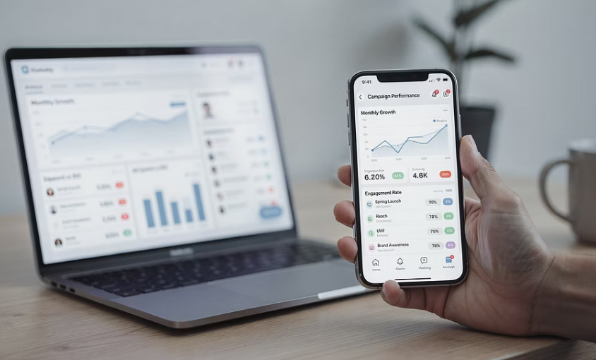 Wirtschaftsdaten gleichzeitig auf Laptop und gehaltenen Phone