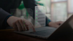 Hand bedient einen Laptop, darüber sind digitale Checklisten mit Häkchen eingeblendet. ©AdobeStock